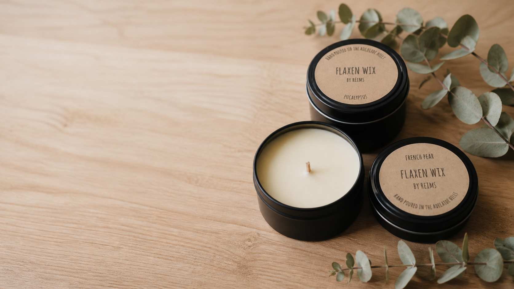 Flaxen Wix candles styled on a calm timber surface